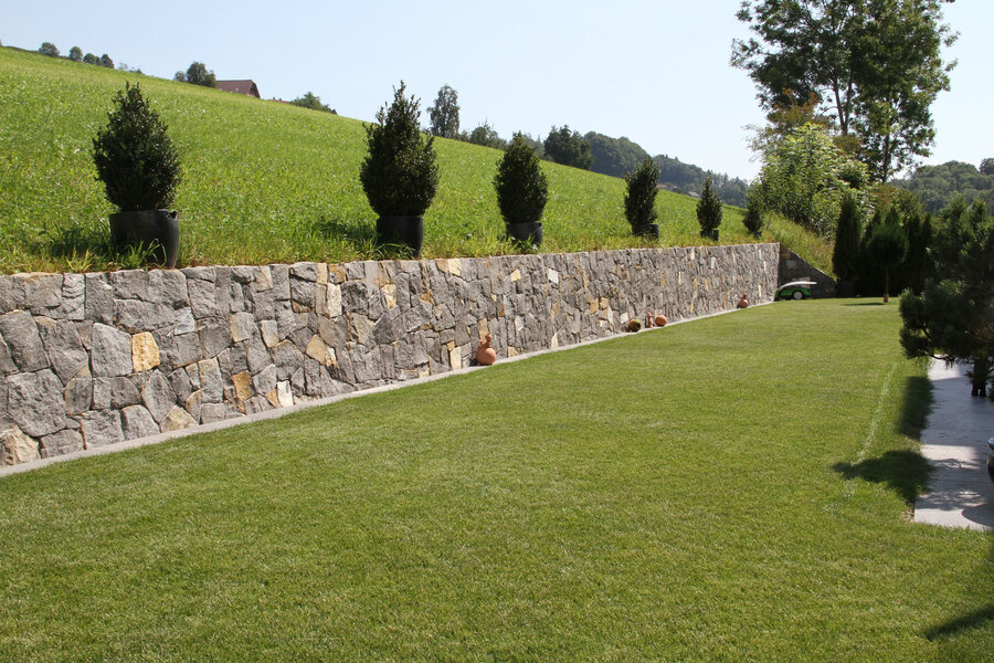 garten_mit_guber_zyklopenmauer_und_gruenem_rasen