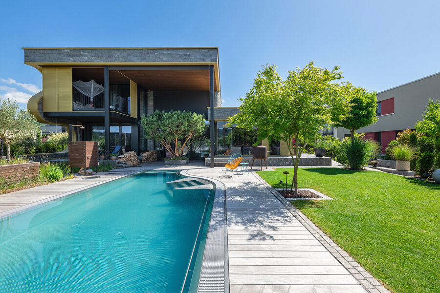 garten_mit_poolbereich_und_grünem_terrain_umgeben_von_modernen_wohngebäuden_und_grünen_pflanzen