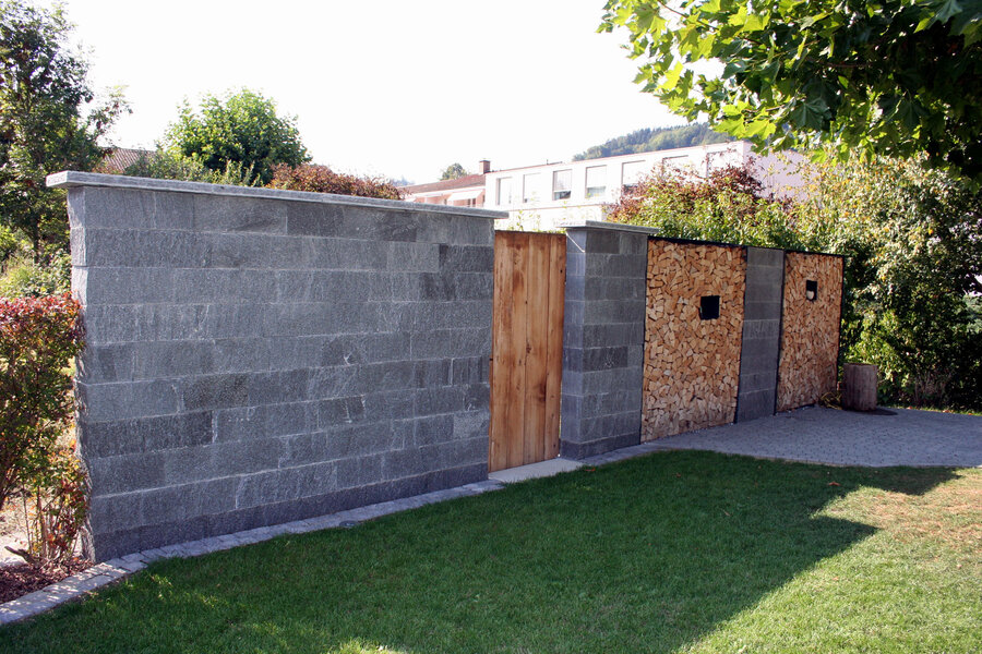 mauer_aus_natursteion_mit_integrierter_holztüre_und_holzlager
