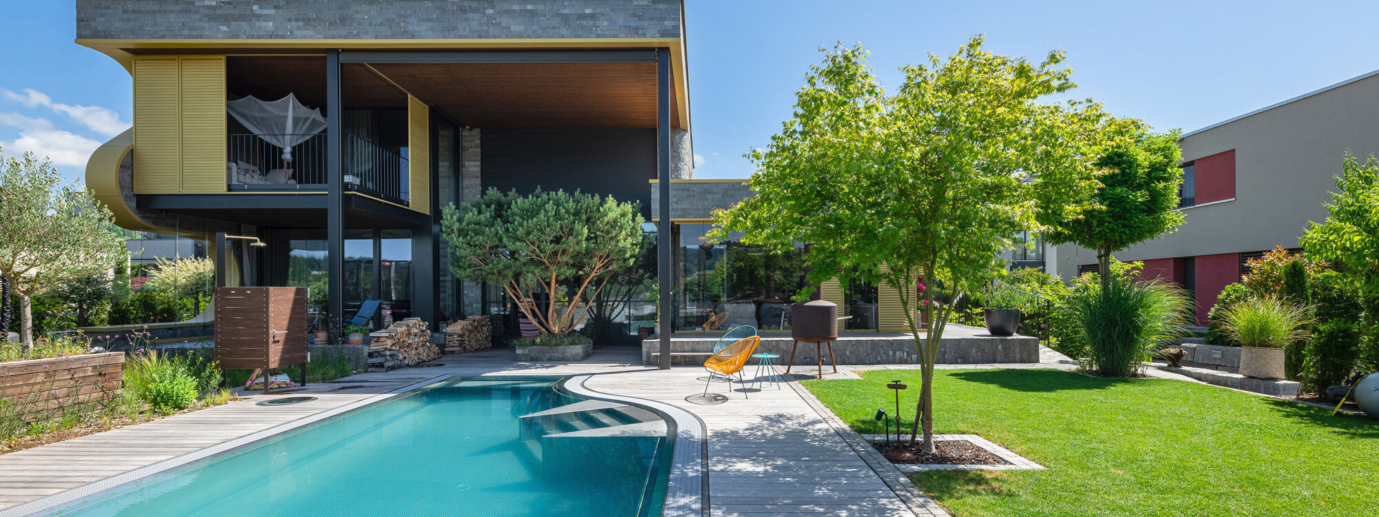 garten_mit_poolbereich_und_grünem_terrain_umgeben_von_modernen_wohngebäuden_und_grünen_pflanzen